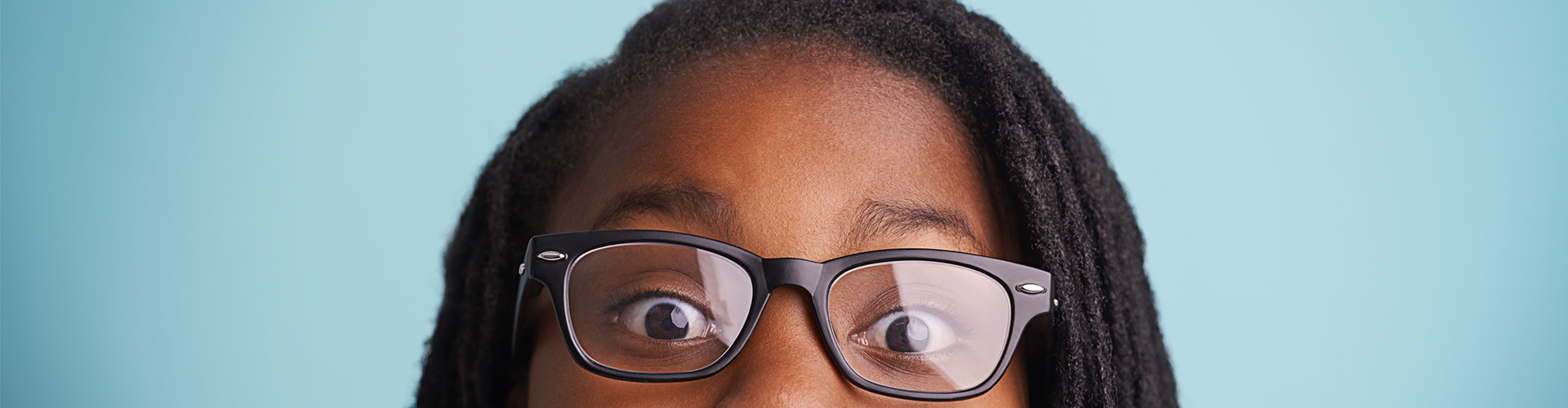 girl with glasses peeking over the edge