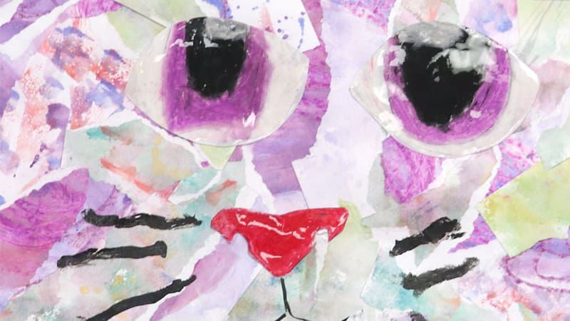 a collage of paper, marker, and other art mediums forming the face of a cat